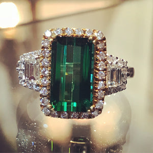 Vivid 2.54 carat emerald cut green tourmaline. 0.74 carats of round brilliant cut and trapezoid diamonds on 18k white and yellow gold